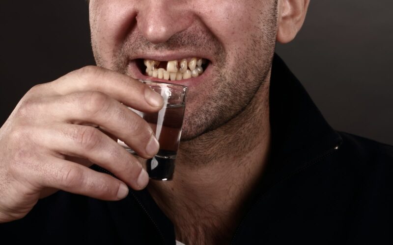 Man with bad teeth drinking alcohol